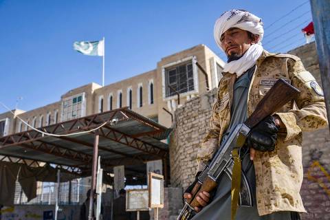 TOPSHOT - An Armed Taliban security personnel stands guard near the closed gate of the zero point border crossing between Afghanistan and Pakistan at Spin Boldak district in Kandahar province on October 12, 2025. Afghanistan and Pakistan said on October 12, they killed dozens of each other's troops during a night of heavy border clashes between the two countries. (Photo by Sanaullah SEIAM / AFP)